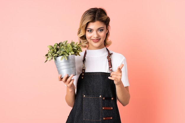 Mujer sosteniendo una planta en estudio