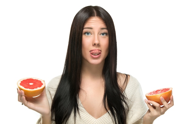 Mujer sosteniendo pomelo sobre blanco