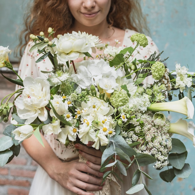 Mujer sosteniendo un ramo de flores blancas