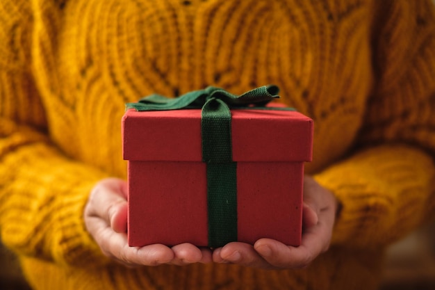 Mujer sosteniendo el regalo rojo de Navidad para regalar el día de Navidad