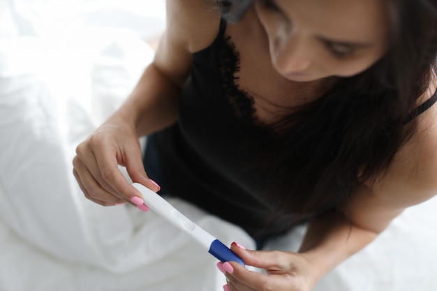 Foto mujer sosteniendo resultados de la prueba de embarazo