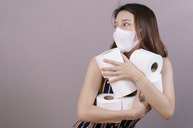 Mujer sosteniendo rollos de papel higiénico