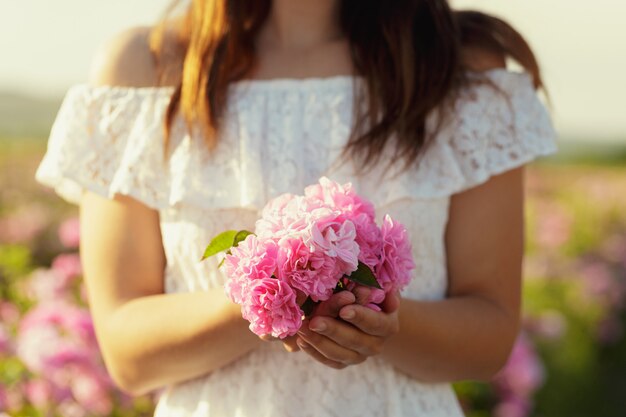 Mujer sosteniendo rosas closeup. Temporada de verano.