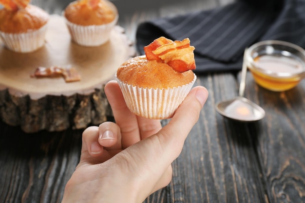 Mujer sosteniendo sabroso muffin de tocino closeup