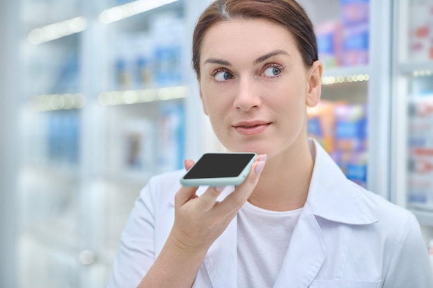 Mujer sosteniendo smartphone a nivel del rostro