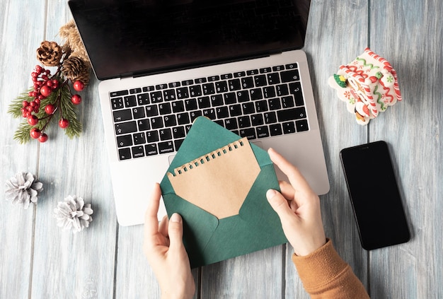 Mujer sosteniendo sobre verde sobre portátil, ambiente navideño en la oficina