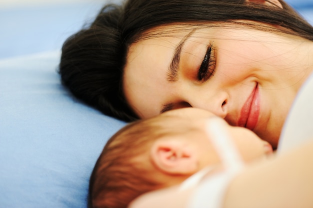 Mujer sosteniendo a su bebé recién nacido en el hospital