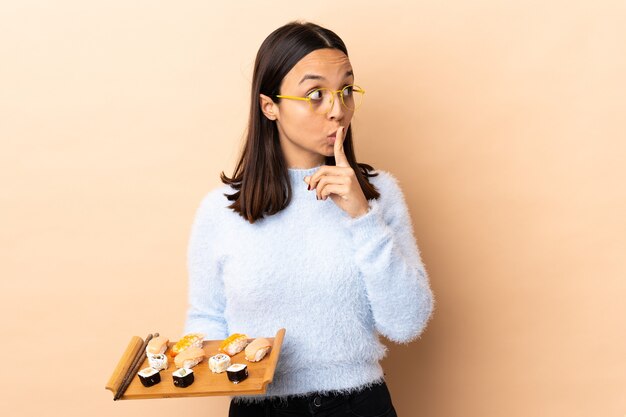 Mujer sosteniendo sushi en estudio