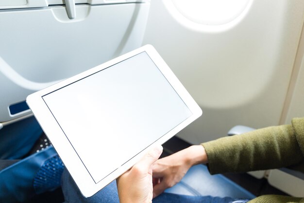 Mujer sosteniendo tableta digital en avión