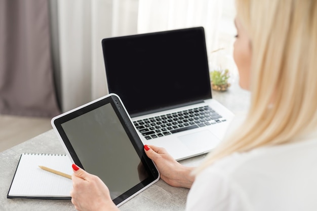 mujer sosteniendo tableta. Hermosa mujer joven que trabaja en su computadora portátil en su oficina.