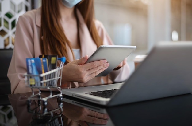 Mujer sosteniendo una tableta y usando una tarjeta de redit Empresaria trabajando en casa Compras en línea Comercio electrónico Banca por Internet Gastar dinero trabajando desde el concepto de hogar