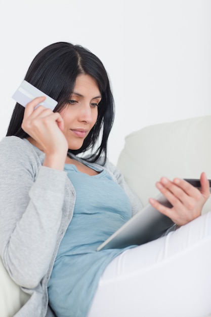 Mujer sosteniendo una tarjeta de crédito y una tableta