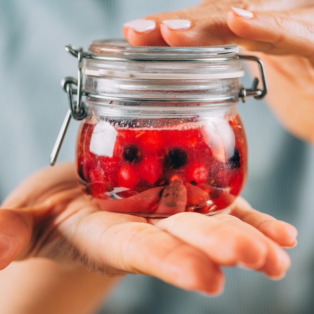 Mujer sosteniendo tarro con fruta fermentada