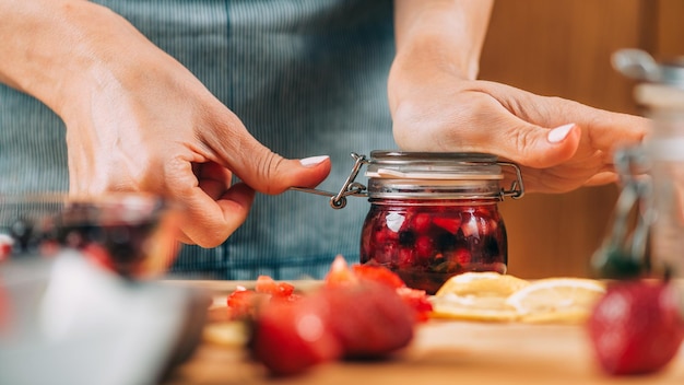 Mujer sosteniendo tarro con fruta fermentada