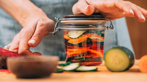 Mujer sosteniendo un tarro con verduras fermentadas