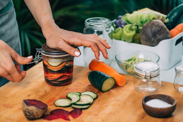 Mujer sosteniendo un tarro con verduras fermentadas