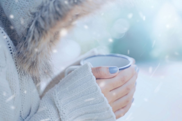 Foto mujer sosteniendo una taza de bebida caliente en invierno al aire libre