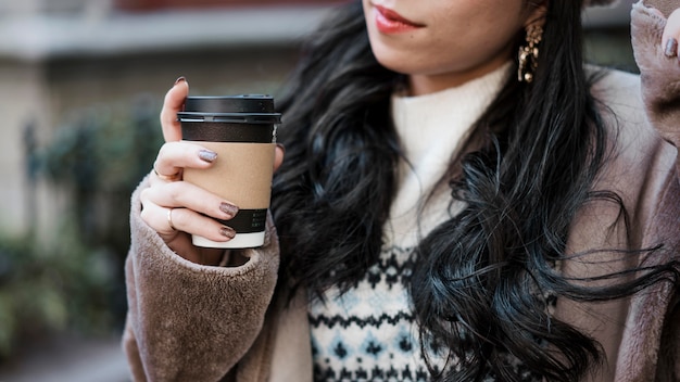 Foto mujer sosteniendo una taza de café al aire libre