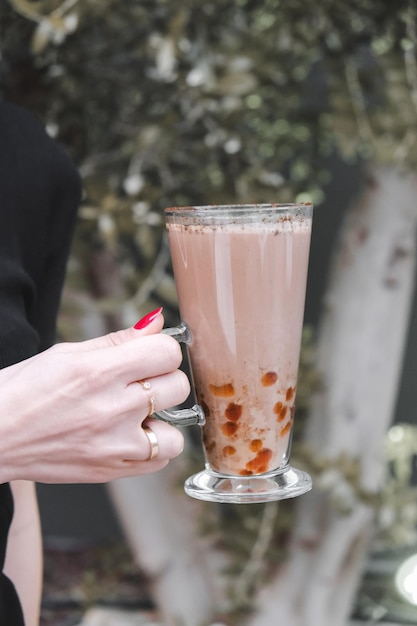 una mujer sosteniendo una taza de café con un esmalte de uñas rojo