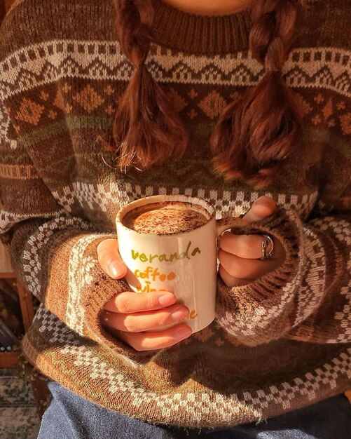 Una mujer sosteniendo una taza de café con la palabra café beluga.