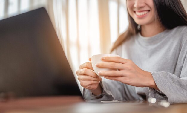 Mujer sosteniendo una taza de café trabaja desde casa espera que la situación de la epidemia mejore pronto en casa. Coronavirus, covid-19, trabajo desde casa (FMH), distanciamiento social, cuarentena, concepto de prevención de infecciones.