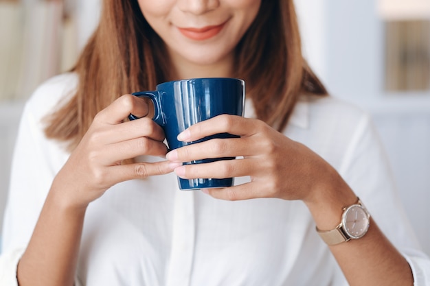 Mujer sosteniendo una taza de café.