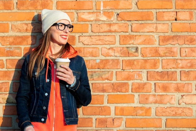 Mujer sosteniendo una taza de papel con café