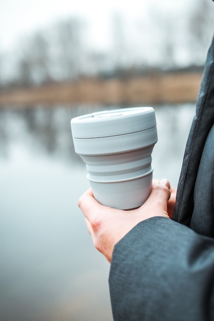 Mujer sosteniendo una taza plegable de silicona, vaso de café reutilizable.