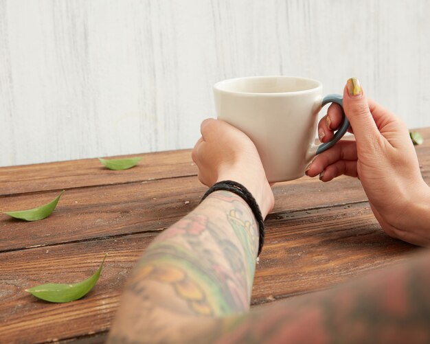 Mujer sosteniendo una taza de té aromático caliente