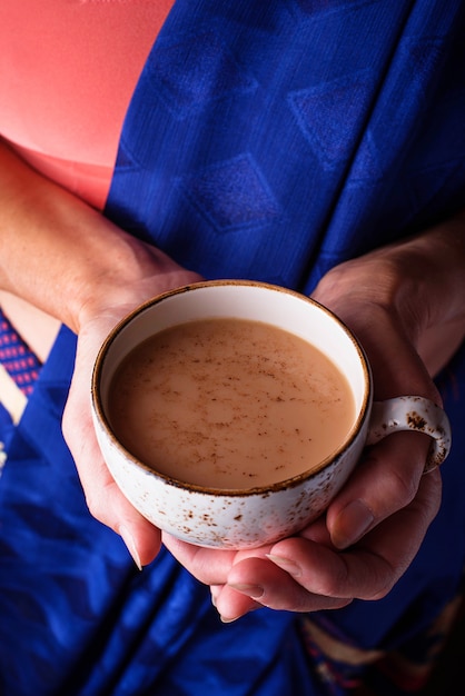 Mujer sosteniendo una taza de té masala