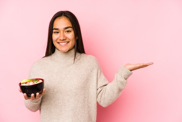 Mujer sosteniendo tazón de sopa de fideos