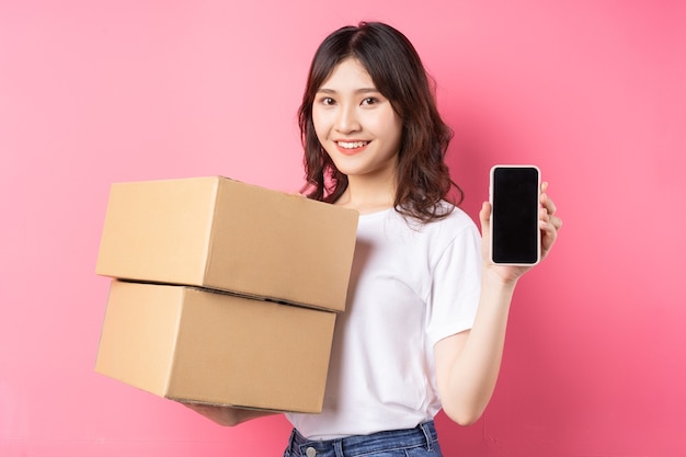 Mujer sosteniendo teléfono y caja de carga riendo alegremente