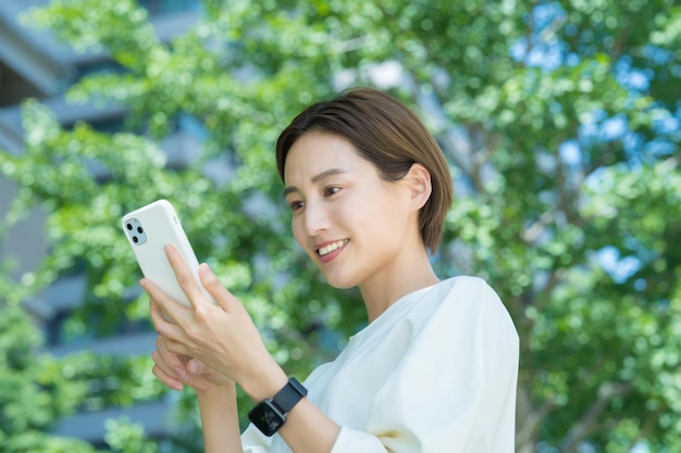 Una mujer sosteniendo un teléfono inteligente al aire libre