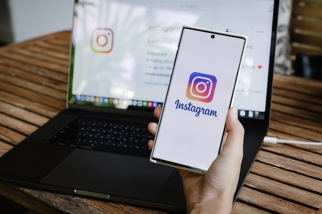 una mujer sosteniendo un teléfono inteligente con la aplicación de Instagram en la pantalla. Instagram es una aplicación para compartir fotos para teléfonos inteligentes.