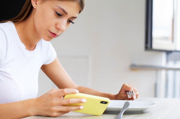 Mujer sosteniendo un teléfono inteligente, escribiendo mensajes, chateando con amigos en las redes sociales.