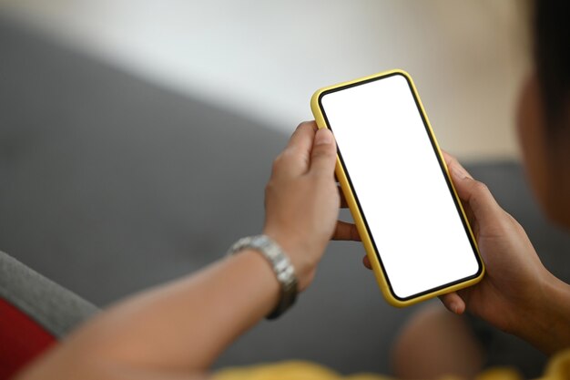 Mujer sosteniendo teléfono móvil con pantalla en blanco en blanco.