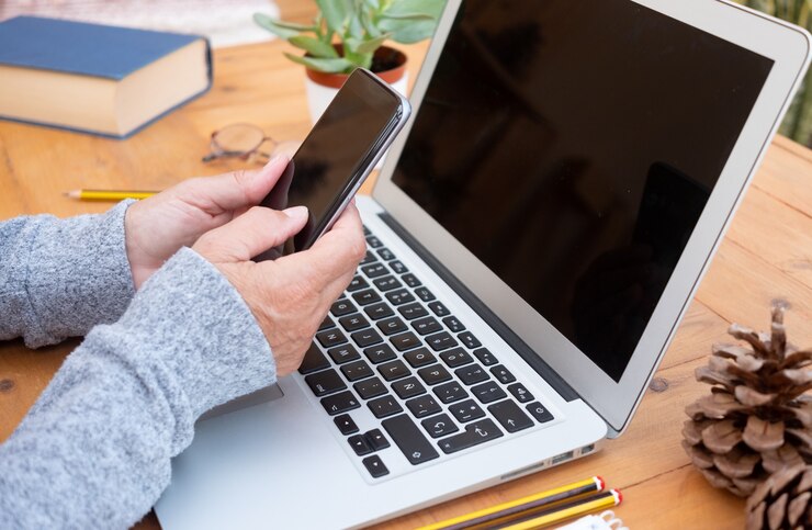 Foto mujer sosteniendo teléfono móvil, usando laptop, compras en línea, aprendizaje en línea, trabajador desde casa. cuarentena, autoaislamiento. freelancer, concepto de nómada digital