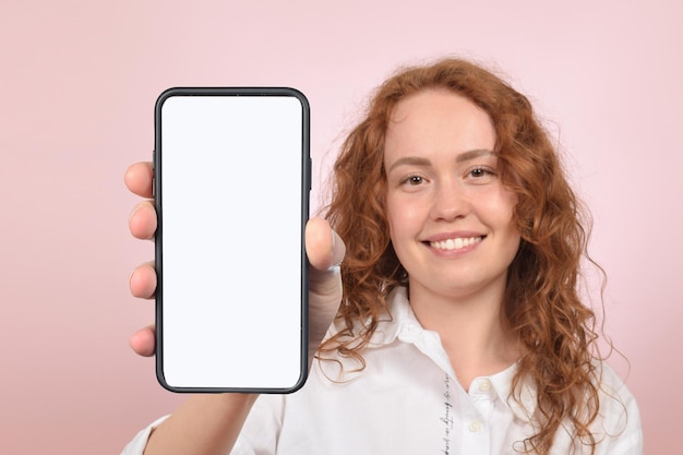 Una mujer sosteniendo un teléfono con una pantalla en blanco