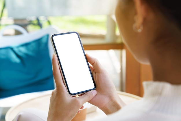 Una mujer sosteniendo un teléfono que muestra una pantalla blanca