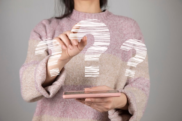 Mujer sosteniendo teléfono con signo de interrogación