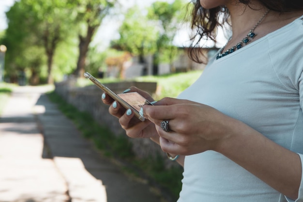 Foto mujer sosteniendo teléfono y tarjeta de crédito en el parque