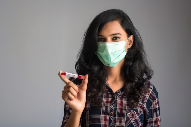 Mujer sosteniendo un tubo de ensayo con muestra de sangre para coronavirus o análisis 2019-nCoV.