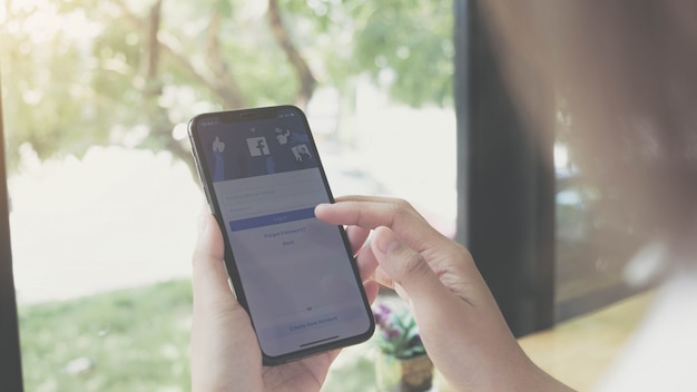 Mujer sosteniendo y usando un teléfono inteligente