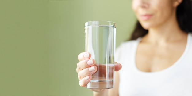 Mujer sosteniendo un vaso de agua.