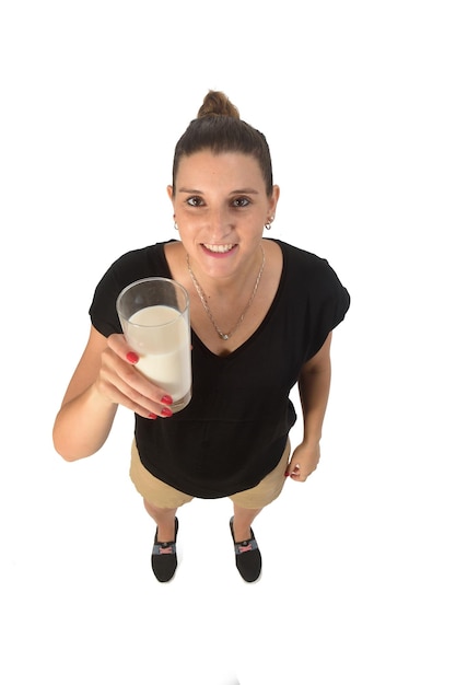 Mujer sosteniendo un vaso de leche sobre fondo blanco.