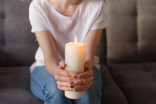 Mujer sosteniendo velas encendidas en sus manos.