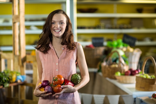 Mujer sosteniendo verduras en la tienda de comestibles