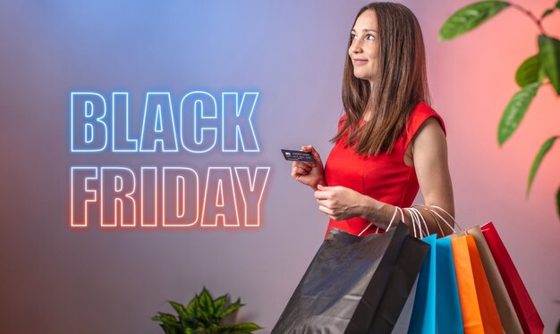 Foto mujer sostiene bolsas de compras y las palabras black friday están escritas junto a