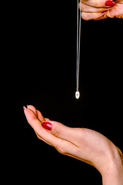 Foto una mujer sostiene una cadena que tiene una gota de agua en ella