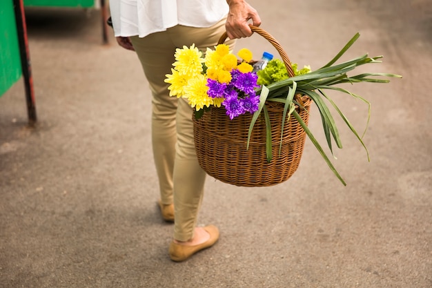 Mujer sostiene una canasta con flores